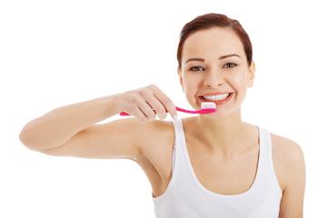 Woman with dental fillings in Edmond, OK brushing her teeth