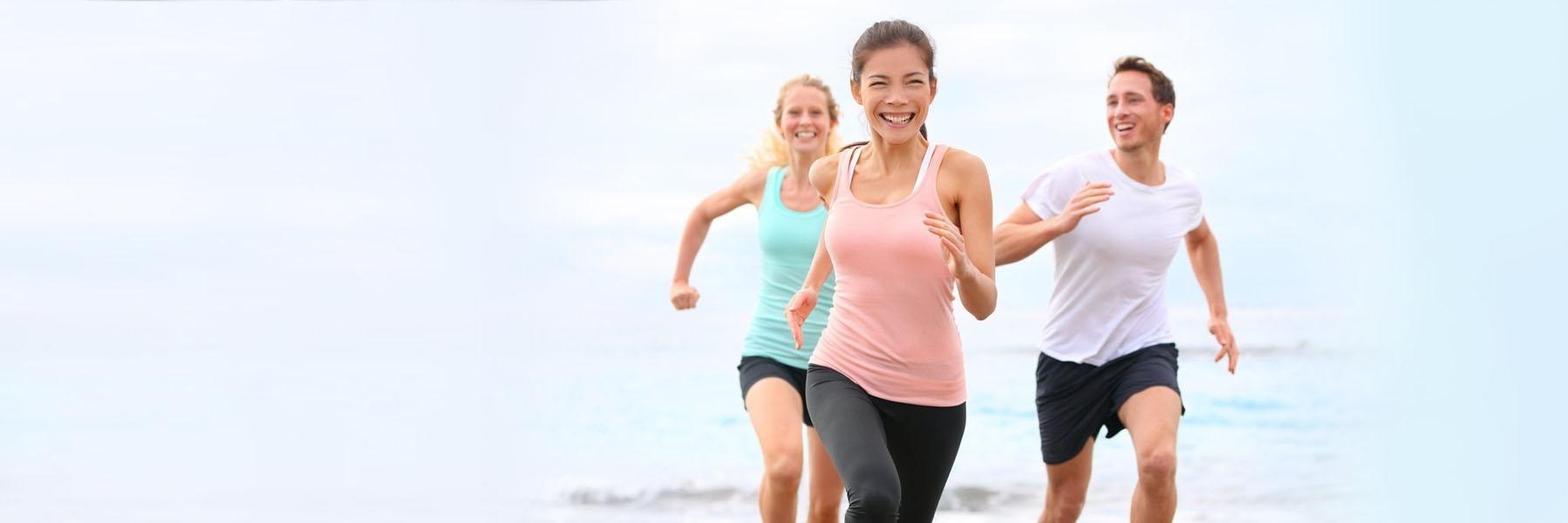 People running on the beach after getting CEREC Crowns Edmond OK
