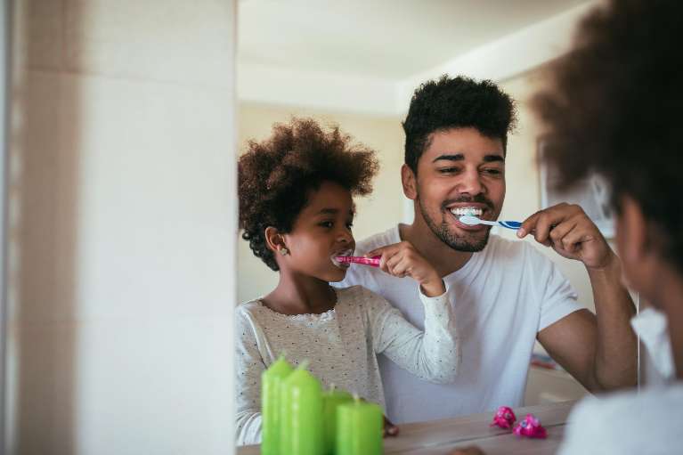 A father and son brushing their teeth together in Edmond, OK